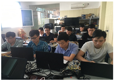 A group of people sitting at computersDescription automatically generated with medium confidence